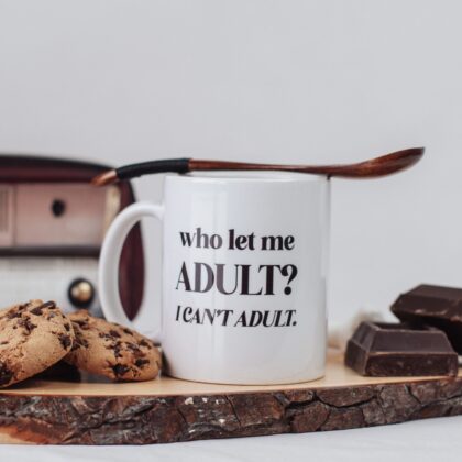 Tazza bianca con su scritto "who let me ADULT? I CAN'T ADULT."