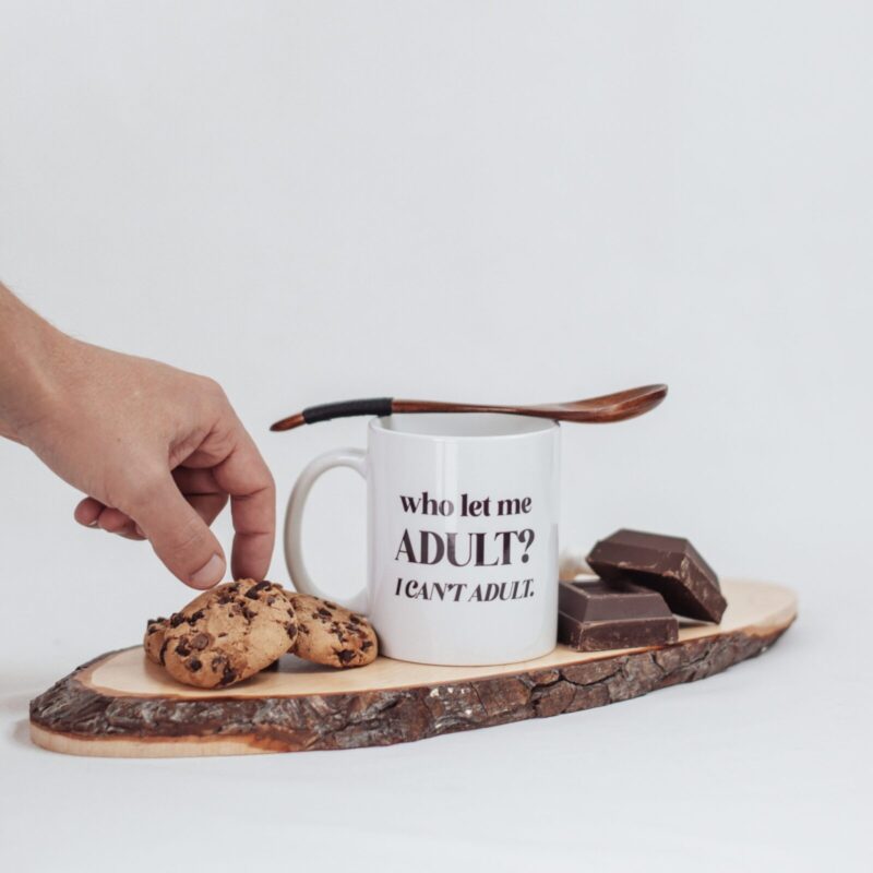 Tazza bianca con su scritto "who let me ADULT? I CAN'T ADULT."